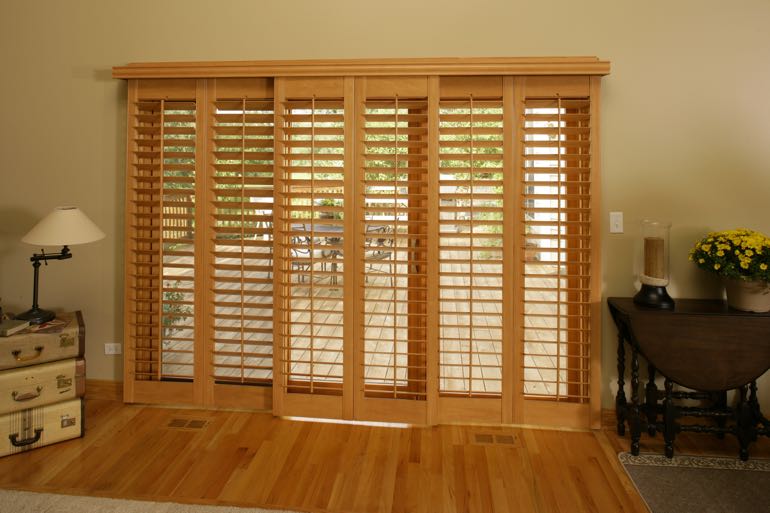plantation shutters on sliding door connecting to full porch.